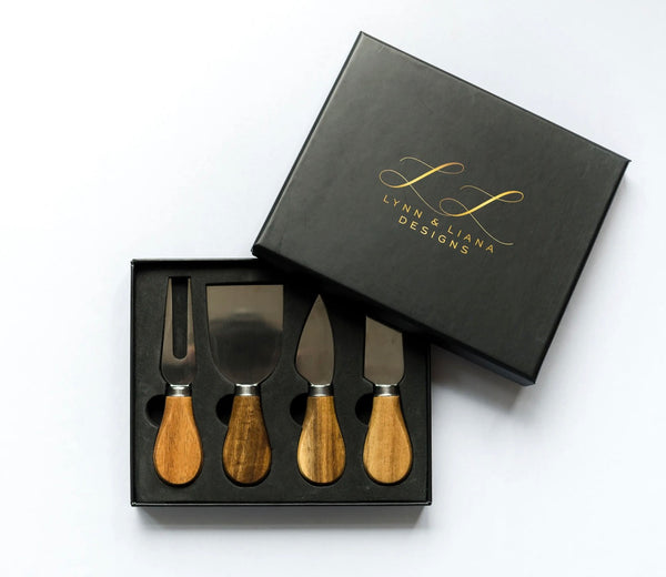 Luxury corporate gift box featuring an acacia serving board, wooden-handle cheese knife set, gourmet olives, and artisan chocolates, arranged in a black gift box with black ribbon.
