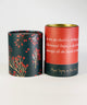 Holiday corporate gift box featuring Christmas tea, a ribbed ceramic mug, artisan chocolates, and a candle, styled with evergreen accents and brown ribbon in a black gift box.