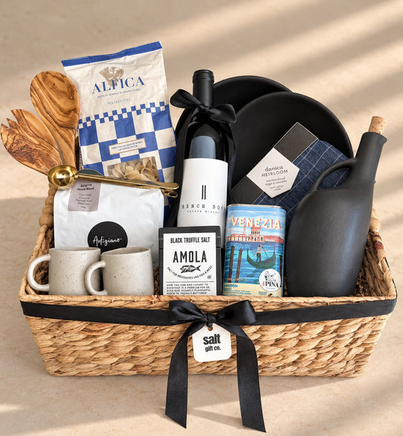 Vancouver Italian-inspired gourmet gift basket with French Door wine, Artigiano’s coffee, Italian pasta, truffle salt, olive oil, ceramic mugs, wooden serving utensils and kitchen linens, beautifully presented in a woven basket.