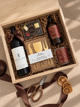 holiday local Christmas gift box with red wine, local chocolates, charcuterie knives, hand poured local candle and soap, client gifting
