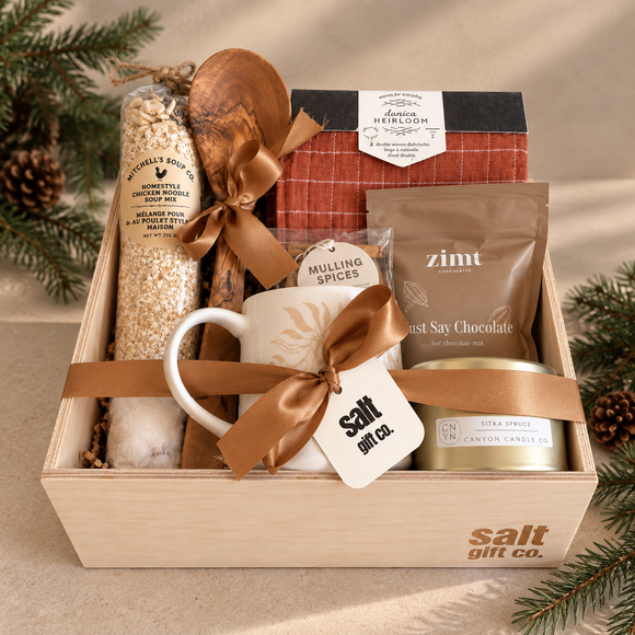 Handmade SALT Gift Co. holiday gift box with apple cranberry crumble mix, mulling spices, Zimt hot cocoa, a Canyon Candle Co. candle, a Danica Heirloom dishtowel, olive wood servers and a mug, chistmas holiday